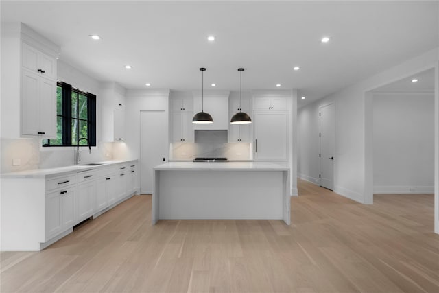 466 Montauk Hwy, Westhampton Beach, NY 11978 - kitchen with light wood-type flooring, decorative backsplash, white cabinets, and recessed lighting
