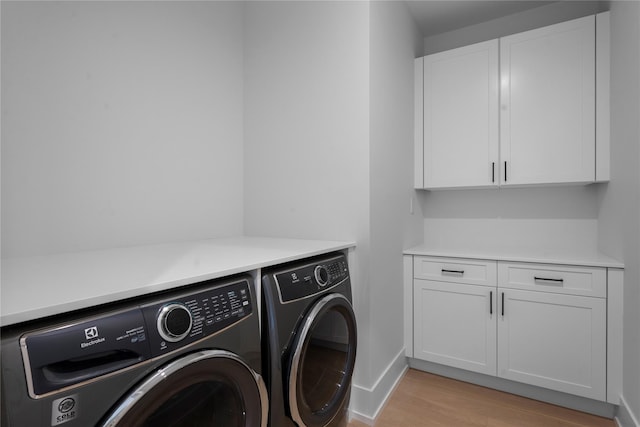 466 Montauk Hwy, Westhampton Beach, NY 11978 - laundry area with washing machine and clothes dryer, light wood-type flooring, and cabinet space