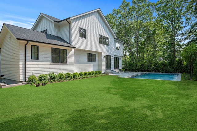 466 Montauk Hwy, Westhampton Beach, NY 11978 - rear view of house featuring roof with shingles, a lawn, and an outdoor pool