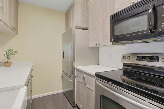 500 Pondside Dr Unit 2E, White Plains, NY 10607 - kitchen featuring appliances with stainless steel finishes, backsplash, dark wood-type flooring, baseboards, and light stone counters
