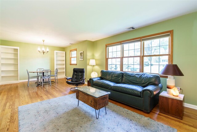 49 Lorraine Dr, Rhinebeck, NY 12572 - living area with baseboards, built in features, a chandelier, and wood finished floors