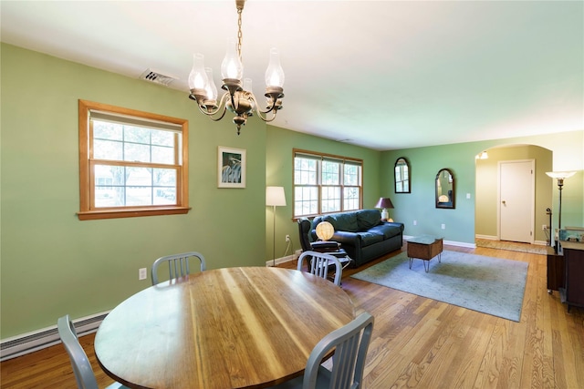 49 Lorraine Dr, Rhinebeck, NY 12572 - dining space featuring a chandelier, arched walkways, light wood finished floors, baseboards, and baseboard heating