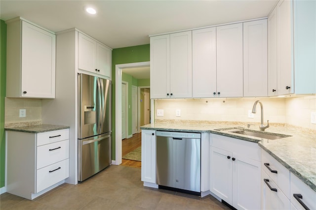 49 Lorraine Dr, Rhinebeck, NY 12572 - kitchen featuring appliances with stainless steel finishes, a sink, white cabinetry, backsplash, and light stone counters