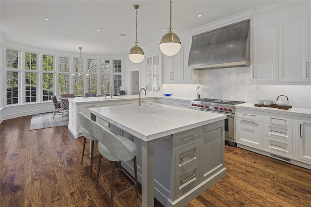 24 Penwood Rd, Bedford Corners, NY 10549 - kitchen with premium range hood, white cabinetry, range with two ovens, and a center island with sink