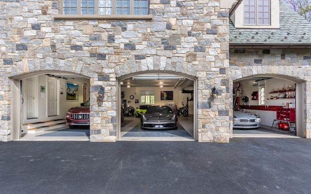 24 Penwood Rd, Bedford Corners, NY 10549 - exterior space with a high end roof, a garage, stone siding, and driveway