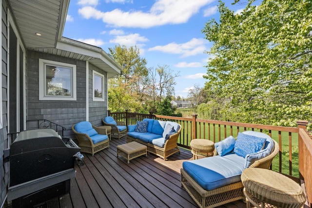 wooden deck with an outdoor hangout area and a grill