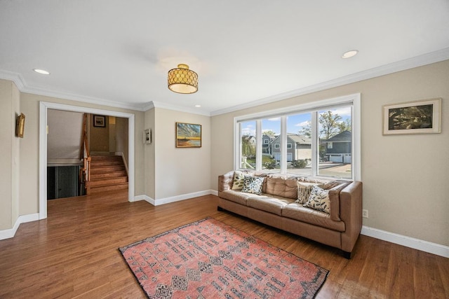 living room with wood finished floors, stairway, baseboards, and ornamental molding
