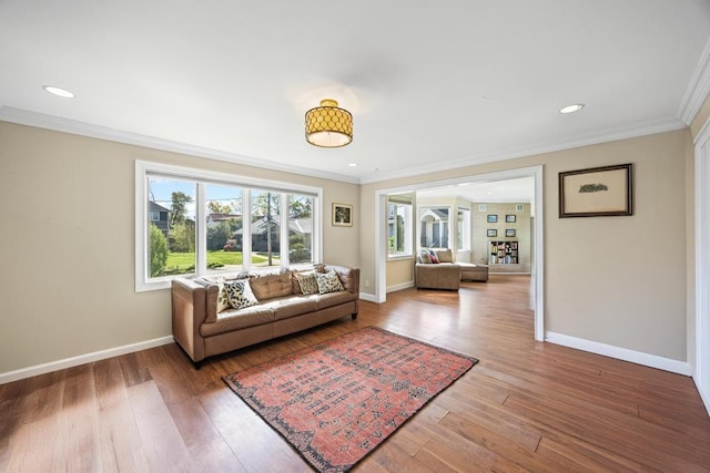 living room with baseboards, ornamental molding, recessed lighting, and wood finished floors