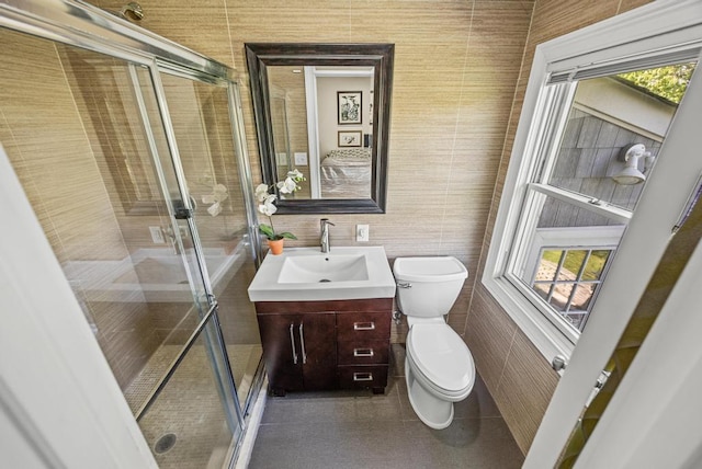full bath with vanity, toilet, tile walls, and a stall shower