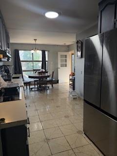 kitchen with freestanding refrigerator and light tile patterned floors