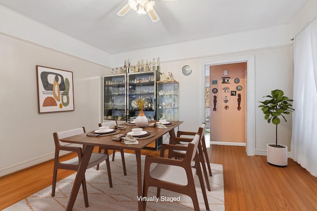 dining room with baseboards, light wood finished floors, and a ceiling fan