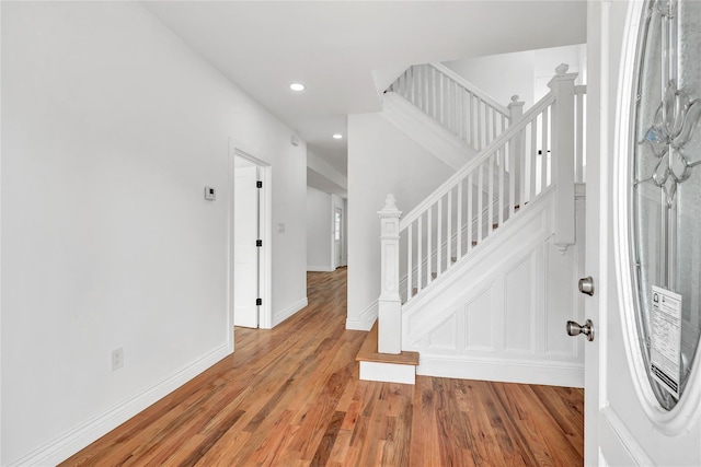 entryway featuring recessed lighting, baseboards, stairs, and light wood-type flooring