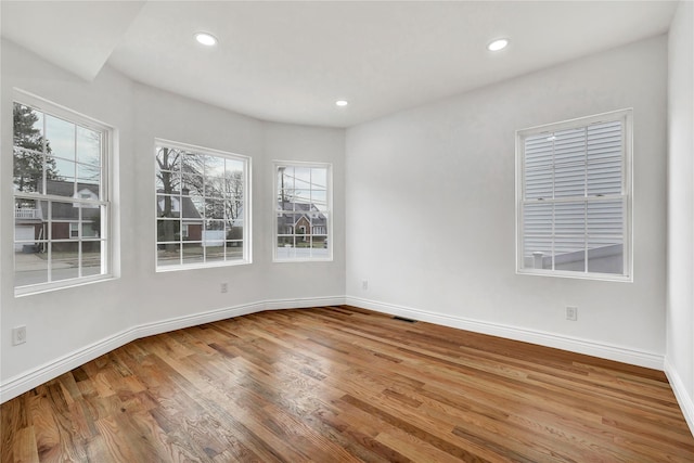 unfurnished room featuring recessed lighting, baseboards, and wood finished floors