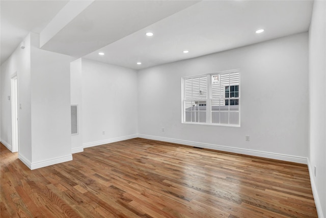spare room with recessed lighting, visible vents, and wood finished floors