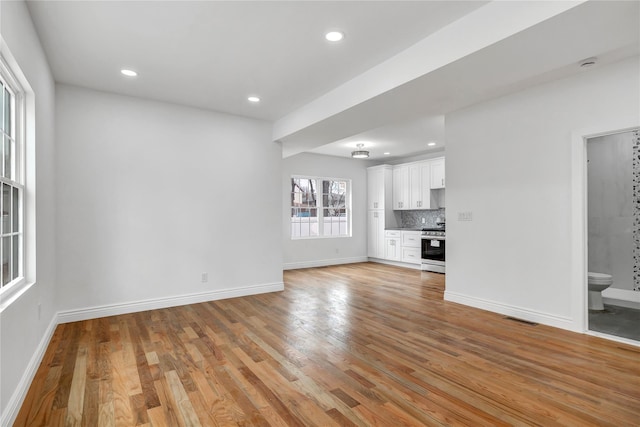 unfurnished living room with baseboards, visible vents, recessed lighting, and light wood finished floors