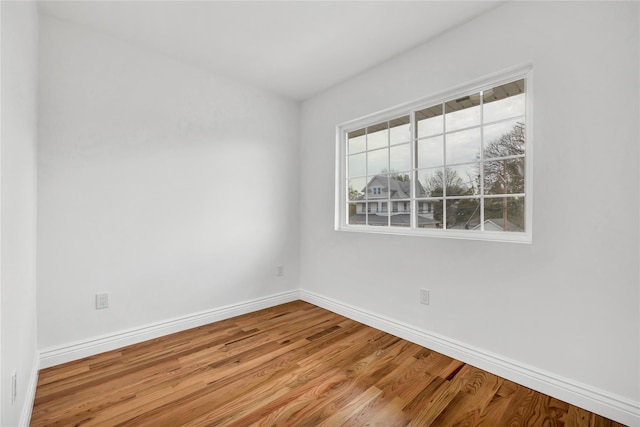 unfurnished room with baseboards and wood finished floors