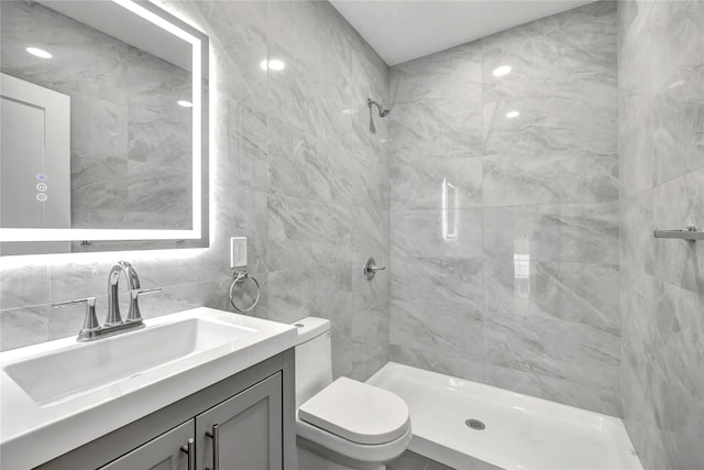 full bath featuring tile walls, toilet, vanity, tiled shower, and backsplash