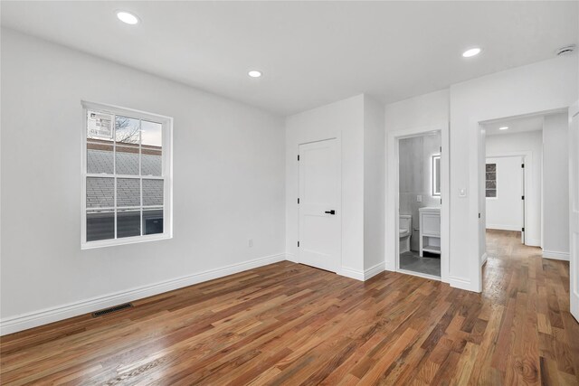unfurnished bedroom with baseboards, visible vents, recessed lighting, and wood finished floors