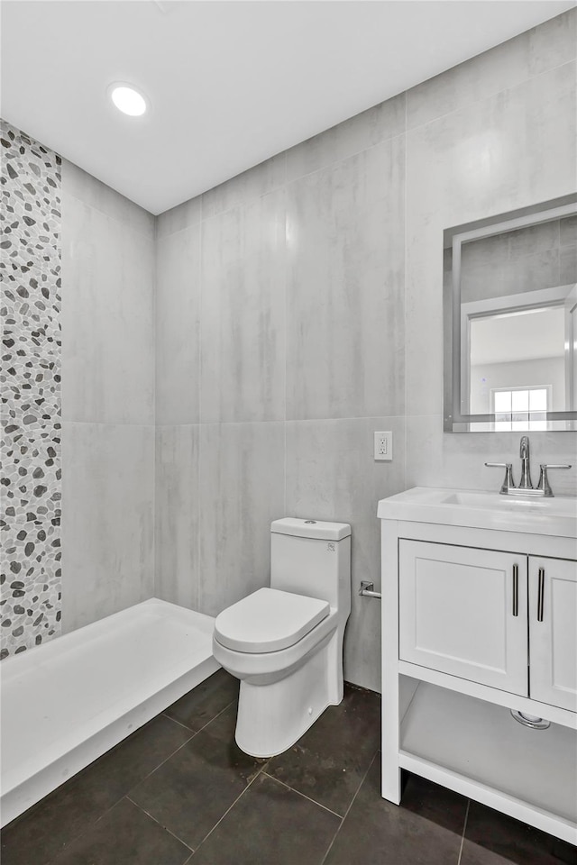 full bathroom featuring toilet, vanity, tile patterned floors, and tiled shower
