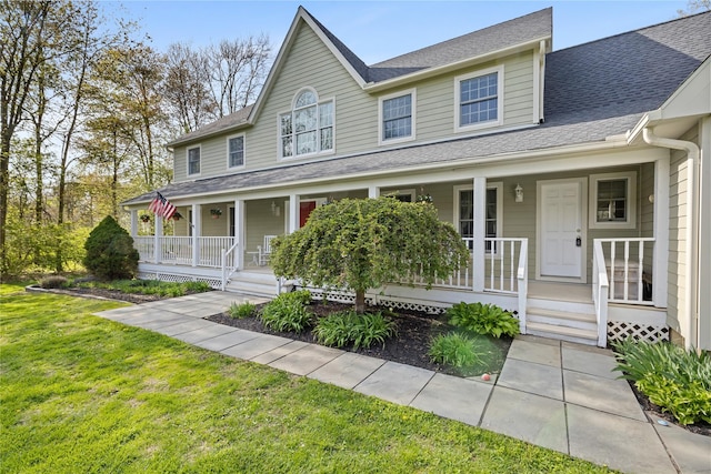 farmhouse-style home featuring a porch, a shingled roof, and a front yard