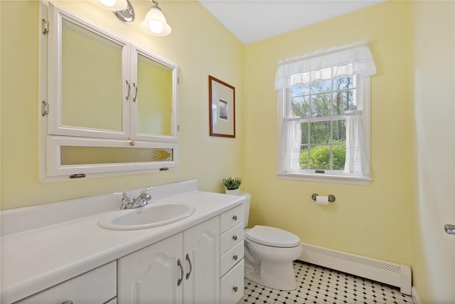 bathroom with toilet, tile patterned floors, baseboard heating, and vanity