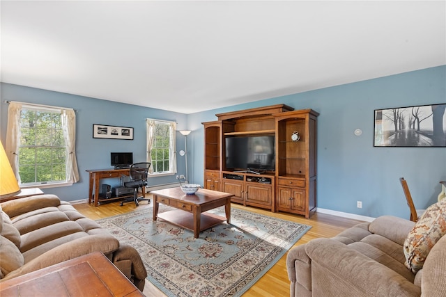 living area featuring light wood-style floors, baseboards, and a wealth of natural light