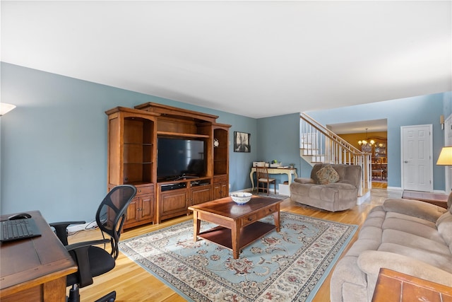 living room with light wood-style floors, baseboards, and a notable chandelier