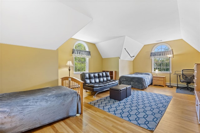 bedroom featuring visible vents, a baseboard radiator, wood finished floors, and lofted ceiling