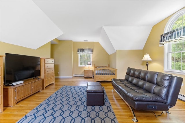 living area featuring vaulted ceiling, baseboards, a baseboard heating unit, and light wood-type flooring