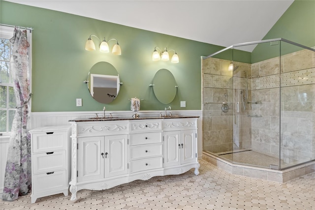 bathroom featuring a sink, a wainscoted wall, and a stall shower