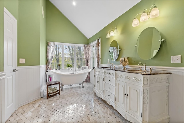 bathroom with a sink, wainscoting, and a freestanding tub