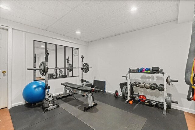 workout room with baseboards, recessed lighting, and a drop ceiling