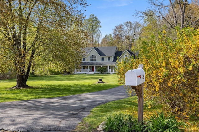 view of front of home with covered porch and a front lawn