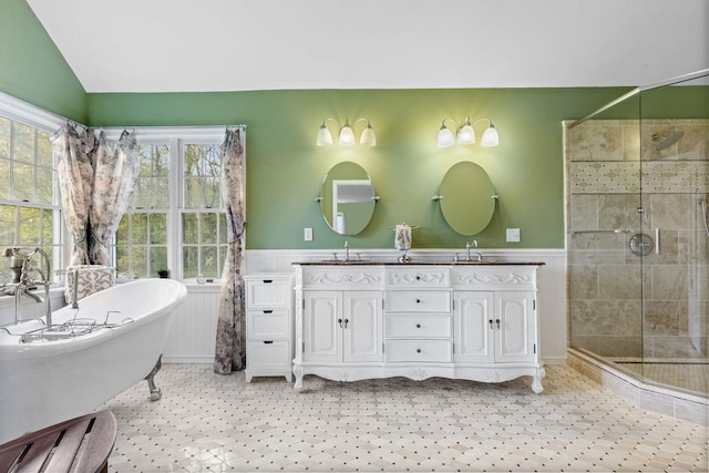 bathroom with a sink, wainscoting, and a stall shower