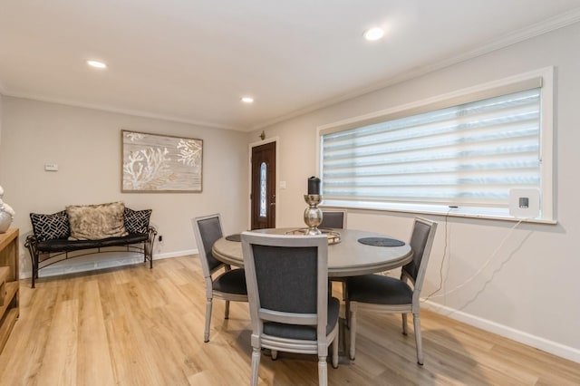 dining space with ornamental molding, light wood-style floors, baseboards, and recessed lighting