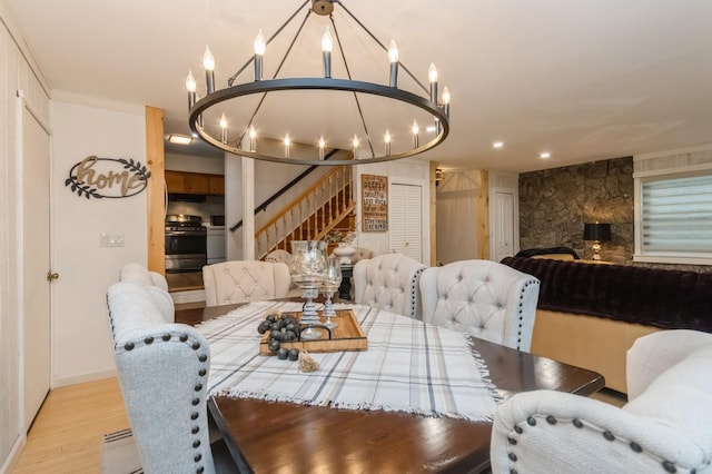 dining area featuring a chandelier, wood finished floors, stairs, baseboards, and recessed lighting