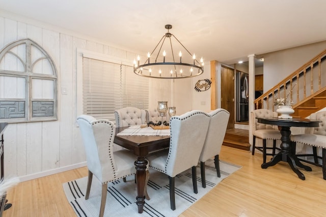 dining room featuring light wood-style floors, a chandelier, and baseboards