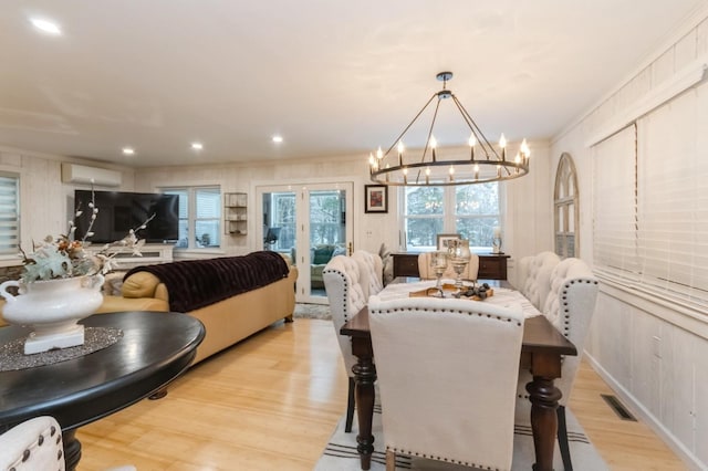 dining area with light wood-type flooring, a chandelier, a wall mounted air conditioner, ornamental molding, and recessed lighting