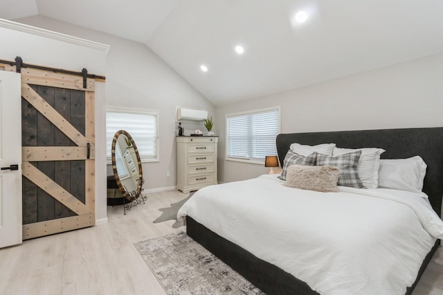 bedroom with vaulted ceiling, an AC wall unit, light wood-style floors, a barn door, and recessed lighting