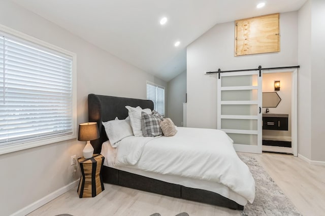 bedroom featuring recessed lighting, baseboards, a barn door, wood finished floors, and vaulted ceiling
