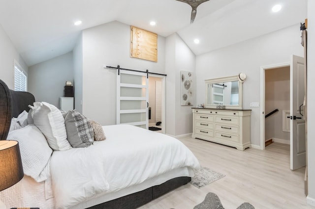 bedroom featuring a barn door, vaulted ceiling, light wood-type flooring, recessed lighting, and baseboards