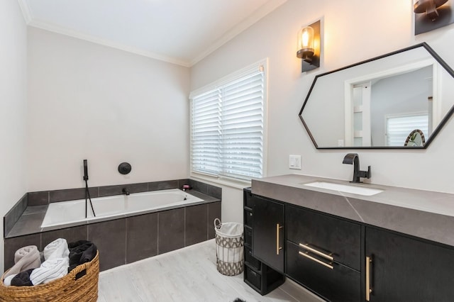 full bathroom featuring ornamental molding, a bath, wood finished floors, and vanity