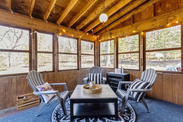 sunroom with lofted ceiling, wooden walls, and carpet floors