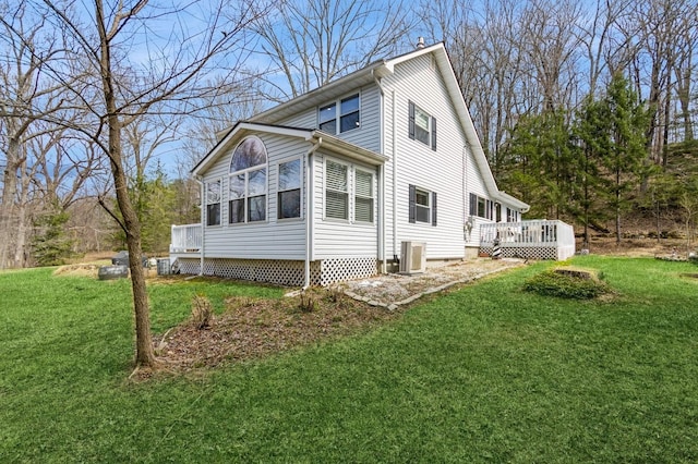 view of side of home featuring a wooden deck, a yard, and central AC unit