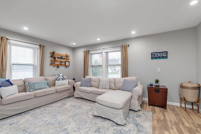 living area featuring baseboards, a wealth of natural light, recessed lighting, and light wood-style floors