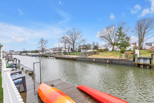 view of dock with a residential view and a water view