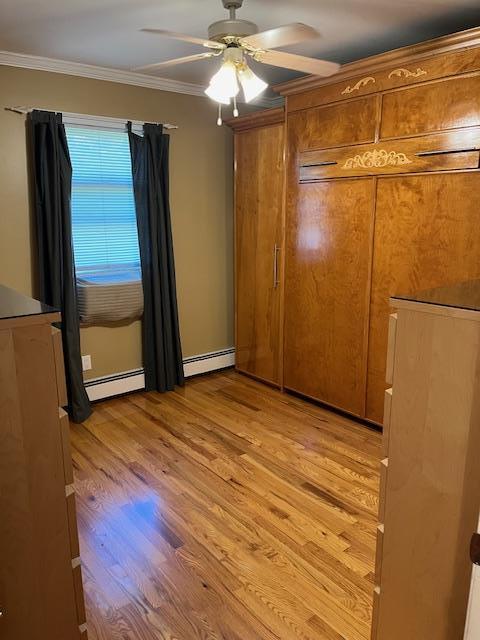 2659 Rte 52, Hopewell Junction, NY 12533 - unfurnished bedroom featuring a ceiling fan, light wood-style flooring, crown molding, and a baseboard heating unit