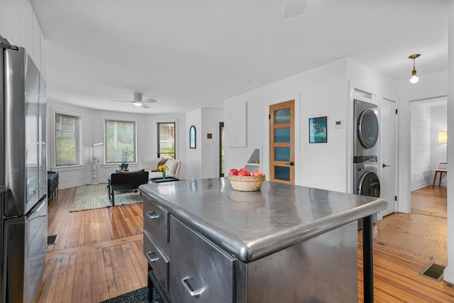 55 Upper Main St, Callicoon, NY 12723 - kitchen featuring freestanding refrigerator, stacked washer / dryer, ceiling fan, and light wood-style floors