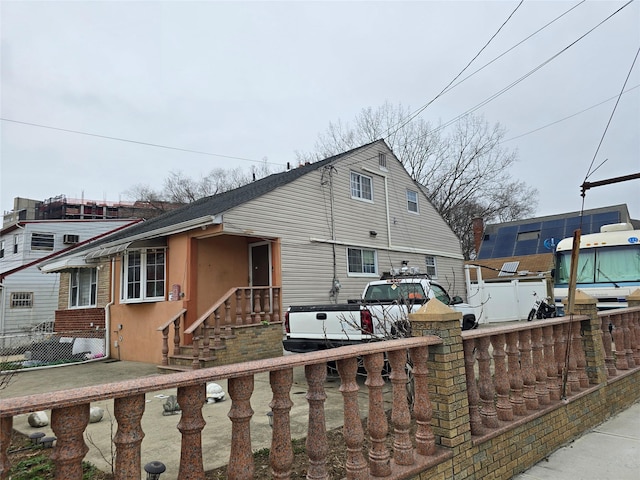 view of front facade featuring stucco siding and fence