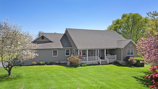rear view of house featuring a porch, a lawn, and roof with shingles
